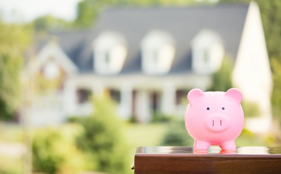 Real estate sale, home savings, loans market concept. Housing industry mortgage plan and residential tax saving strategy. Piggy bank isolated outside home on background. Focus on piggybank. Homeowner-1